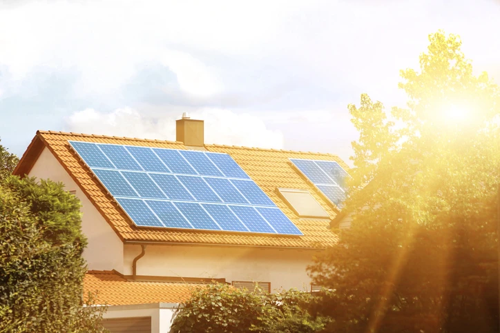 Casa residencial com painéis solares instalados no telhado, aproveitando energia solar para sustentabilidade e economia de energia.