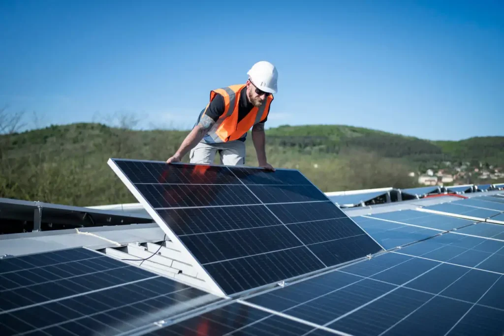 Engenheiro instalando painel solar em usina solar ao ar livre, promovendo energia renovável e sustentável.