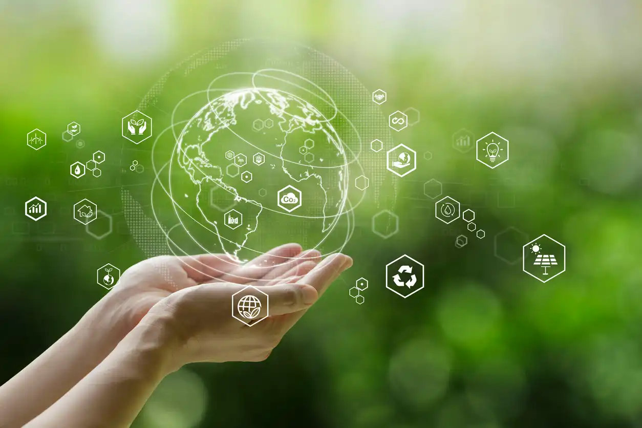 Mãos segurando uma representação digital do planeta Terra com ícones relacionados ao meio ambiente, energia solar, reciclagem e sustentabilidade, simbolizando tecnologias ecológicas e energia renovável.